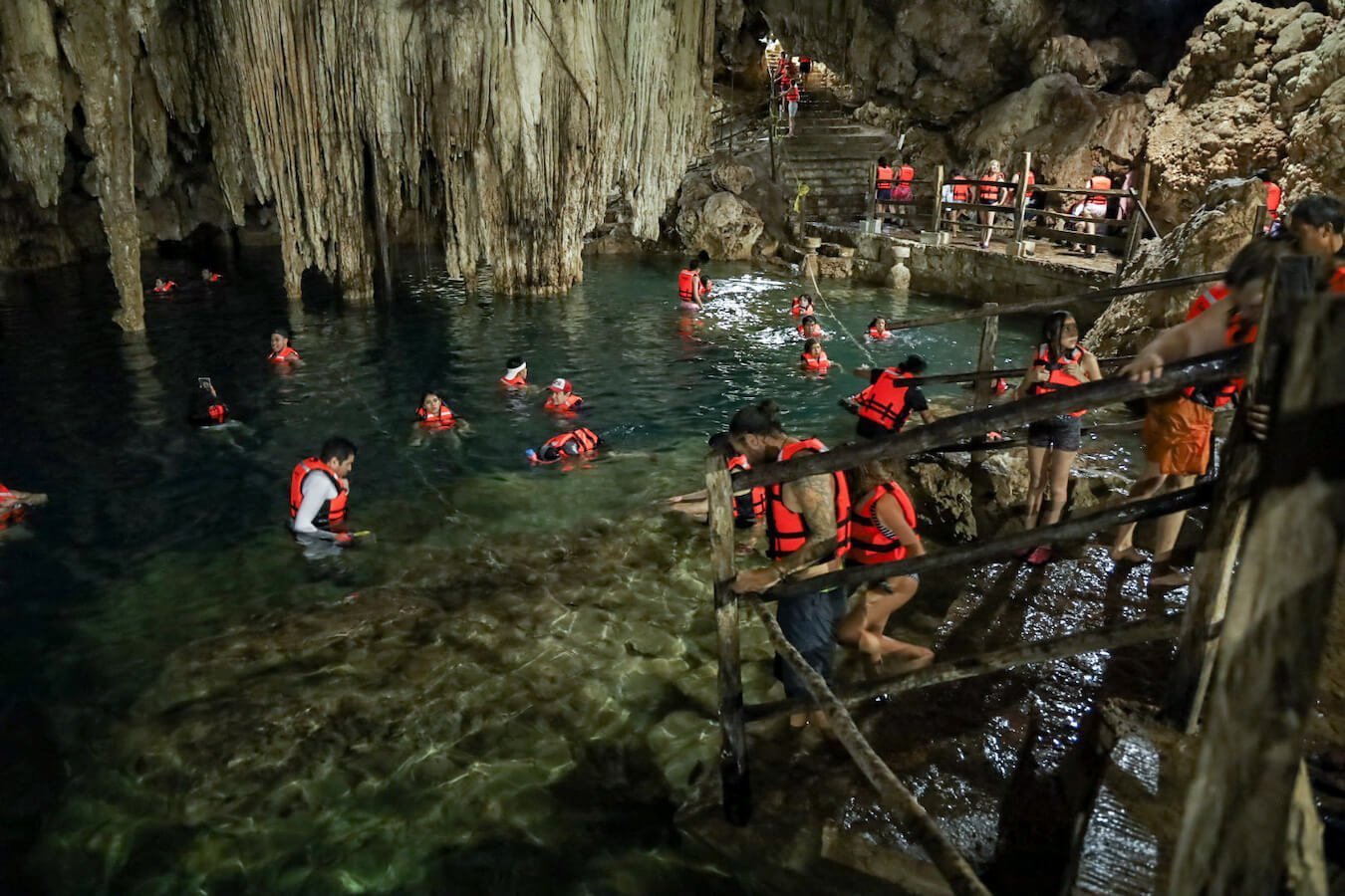 People swim in the cave like enclosed Cenote Xkeken in Dzitnup near Valladolid