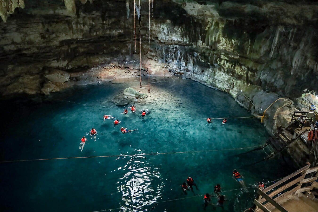 Visitors swim in Samula, an enclosed cave like cenote with turquoise water at Dzitnup near Valladolid.