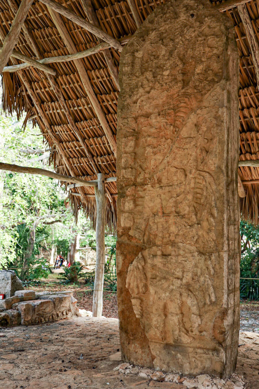 Walking on self-guided tour of Ek' Balam - Stela - Monument - of Ukit Kan Le’k Tok' - a large stone carving under a small palapa in Mexico