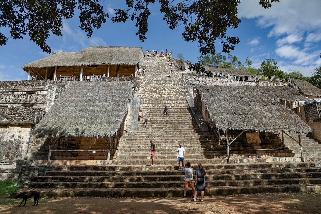 Visitors walking the impressive stairs leading up the side of the Acropolis or Royal Palace at Ek' Balam ruins near Valladolid in Mexico