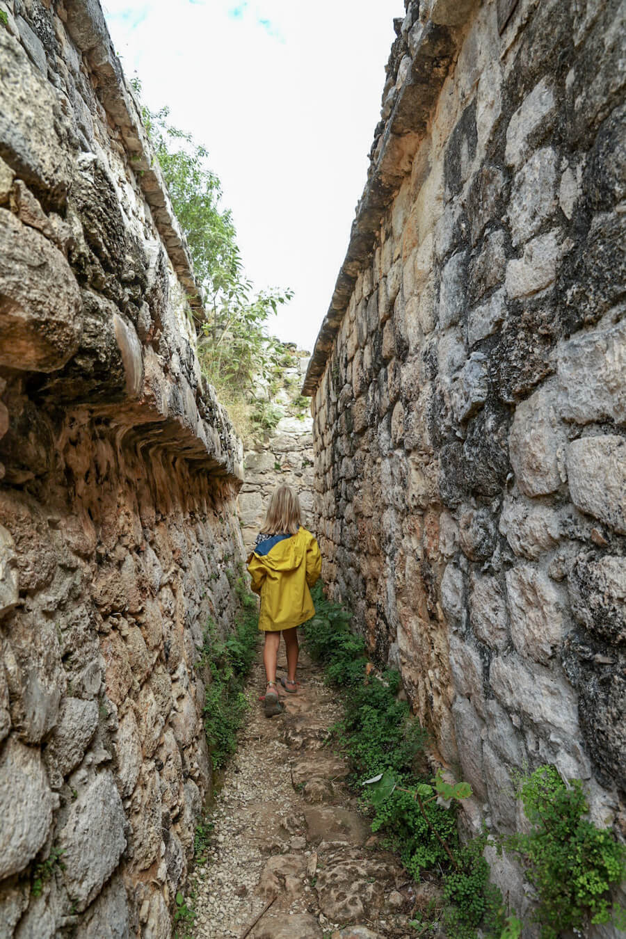 A child walks between the ruins at Ek' Balam while on a self-guided tour.
