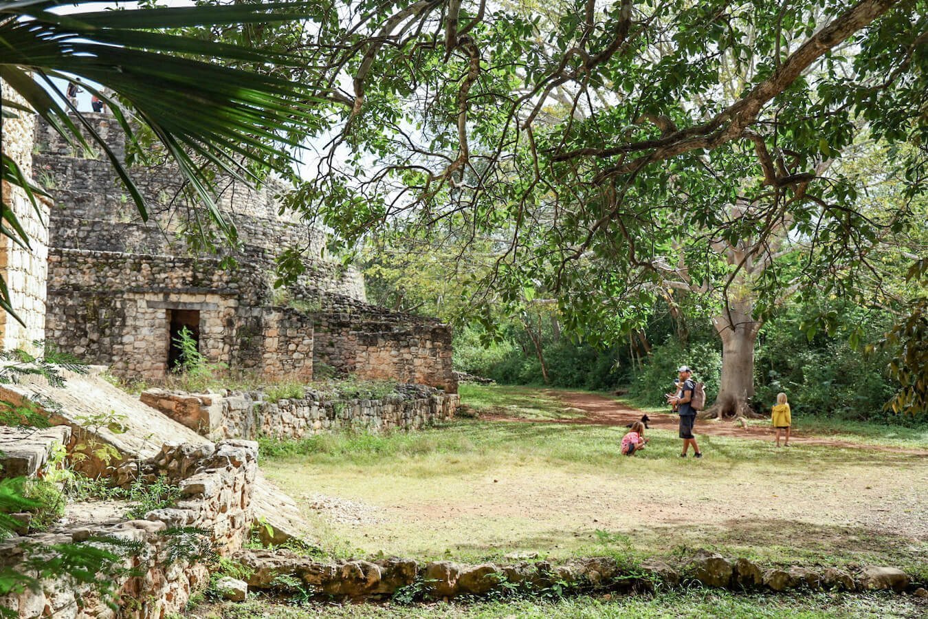 A family walk on a self-guided tour of Ek' Balam through the jungle landscape in Mexico