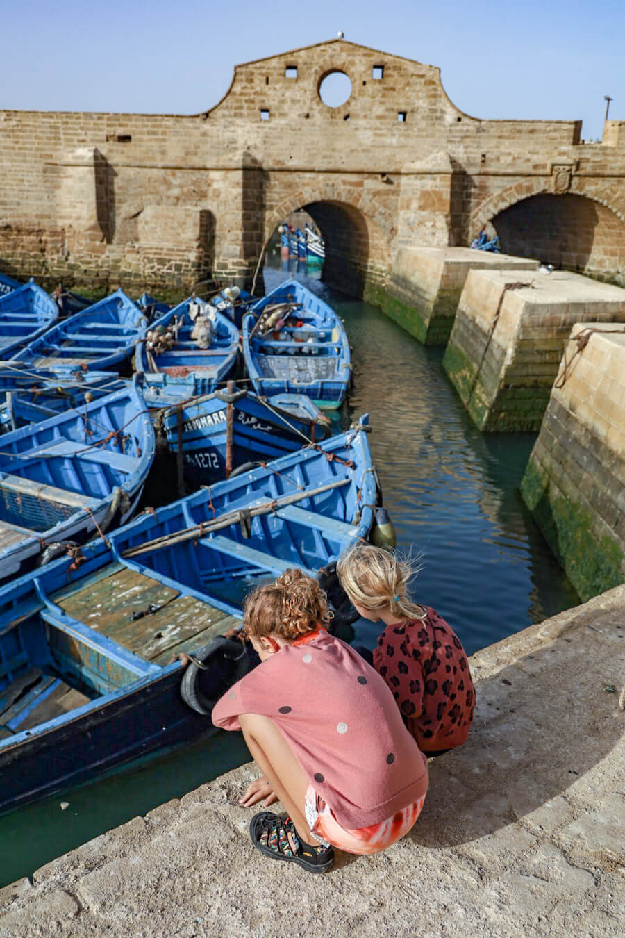 Kids watch the fishing boats near Port du Skala in Essaouira - a travel guide