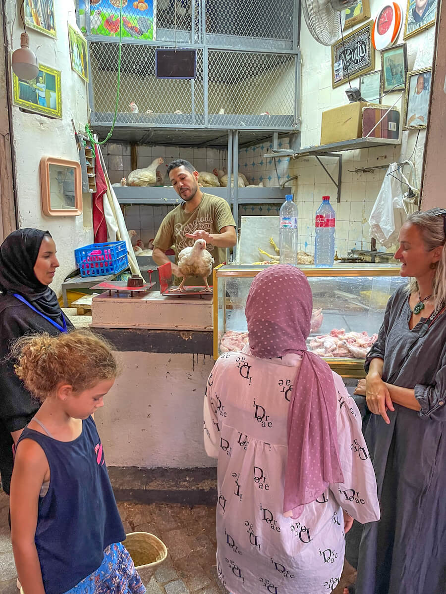 A chicken is placed on scales at the butcher in the Fes Medina