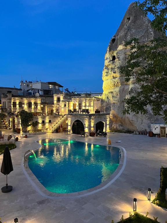 Göreme Cave Suites Hotel in Cappadocia lit at night with pool.