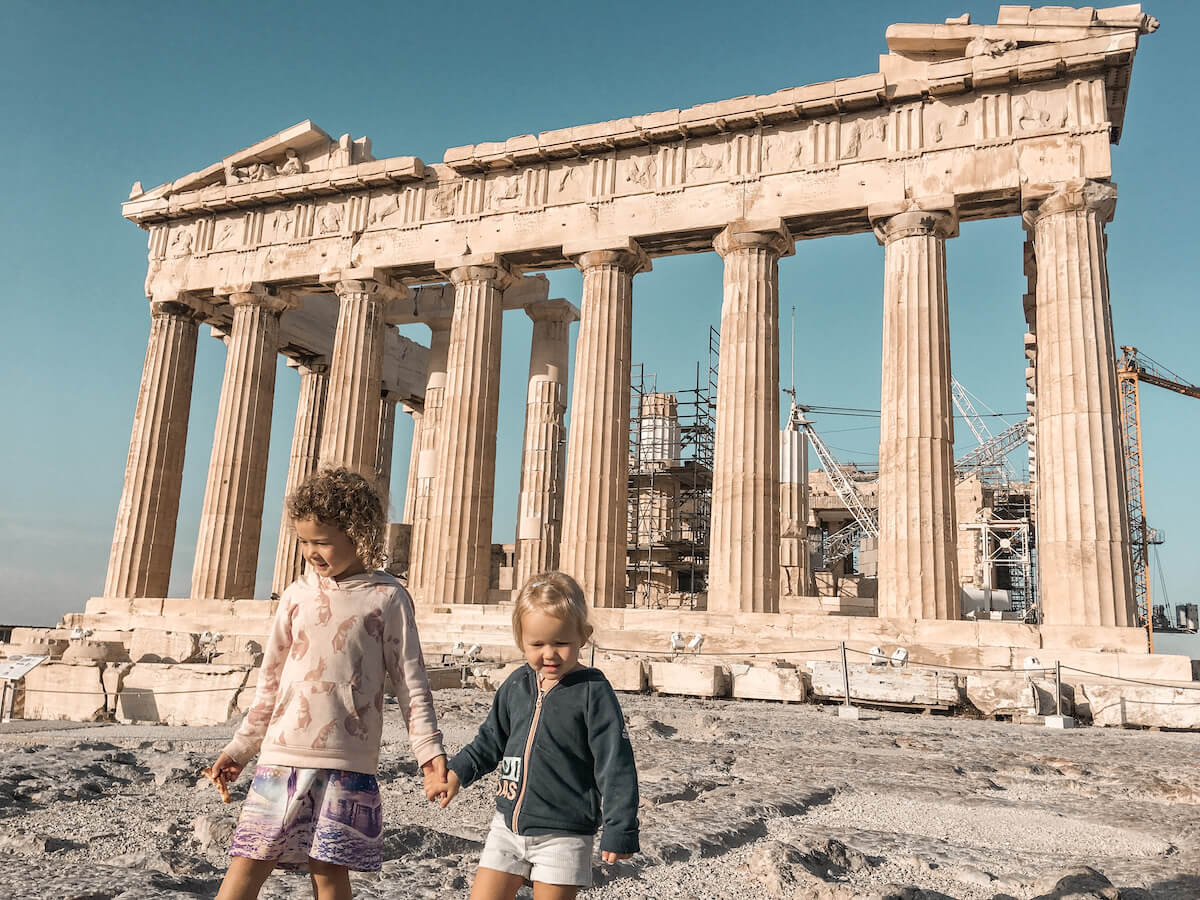 Two kids walk hand in hand in at the Acropolis in Athens Greece
