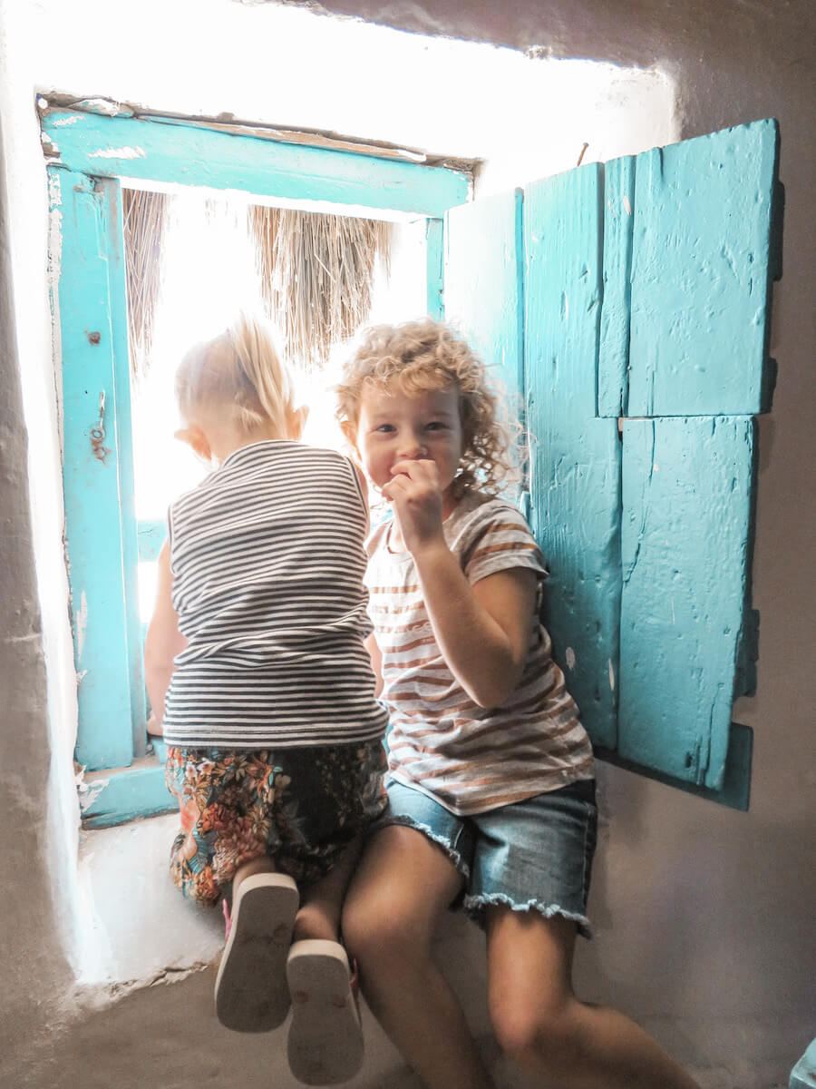 Kids peek out the windmill window in Mykonos