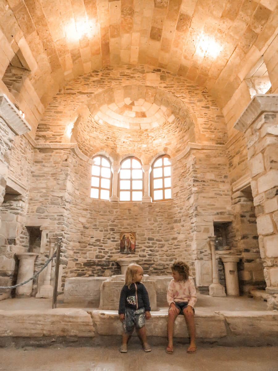 Two kids sit in an ancient church in Paros Greece