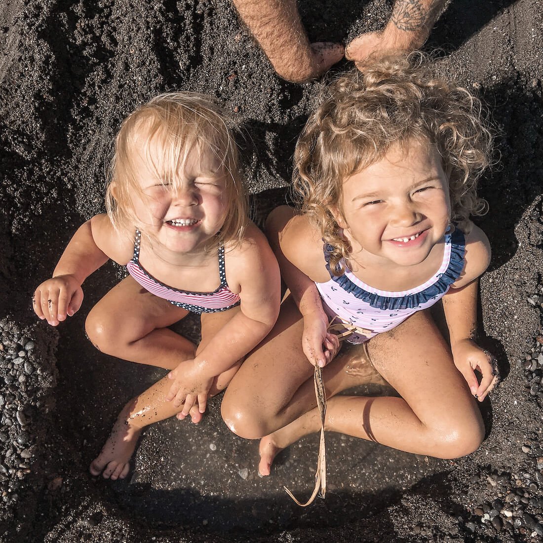 Two young children at the black sand beaches in Santorini