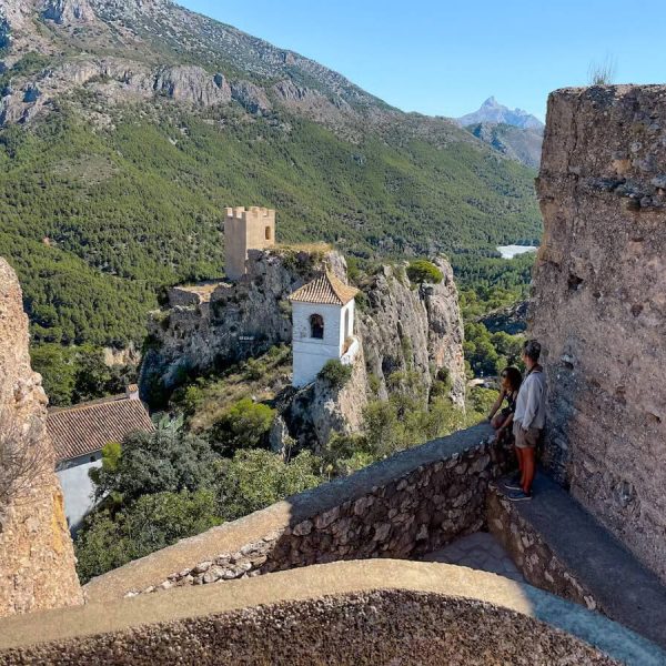 A family overlook Guadalest Valley from the San Jose Castle Ruins on a day trip from Javea