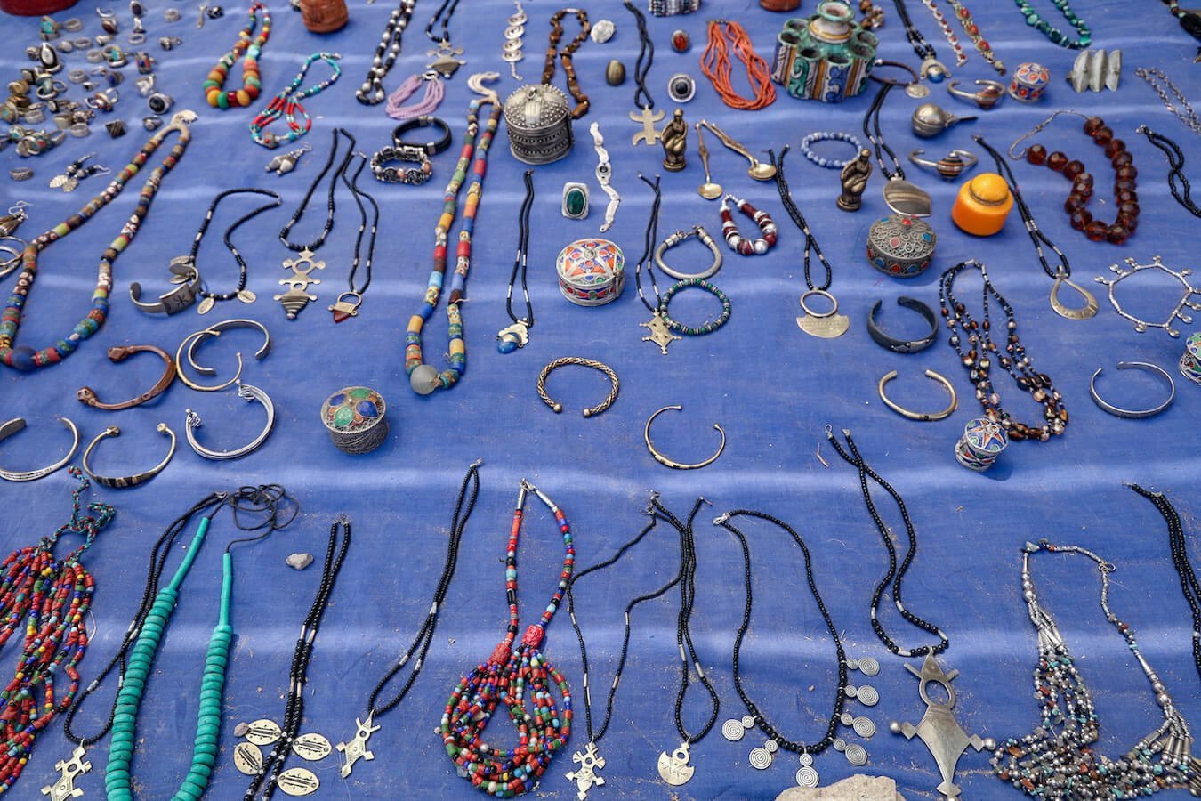 Antique jewellery on a blue mat at a market in Morocco
