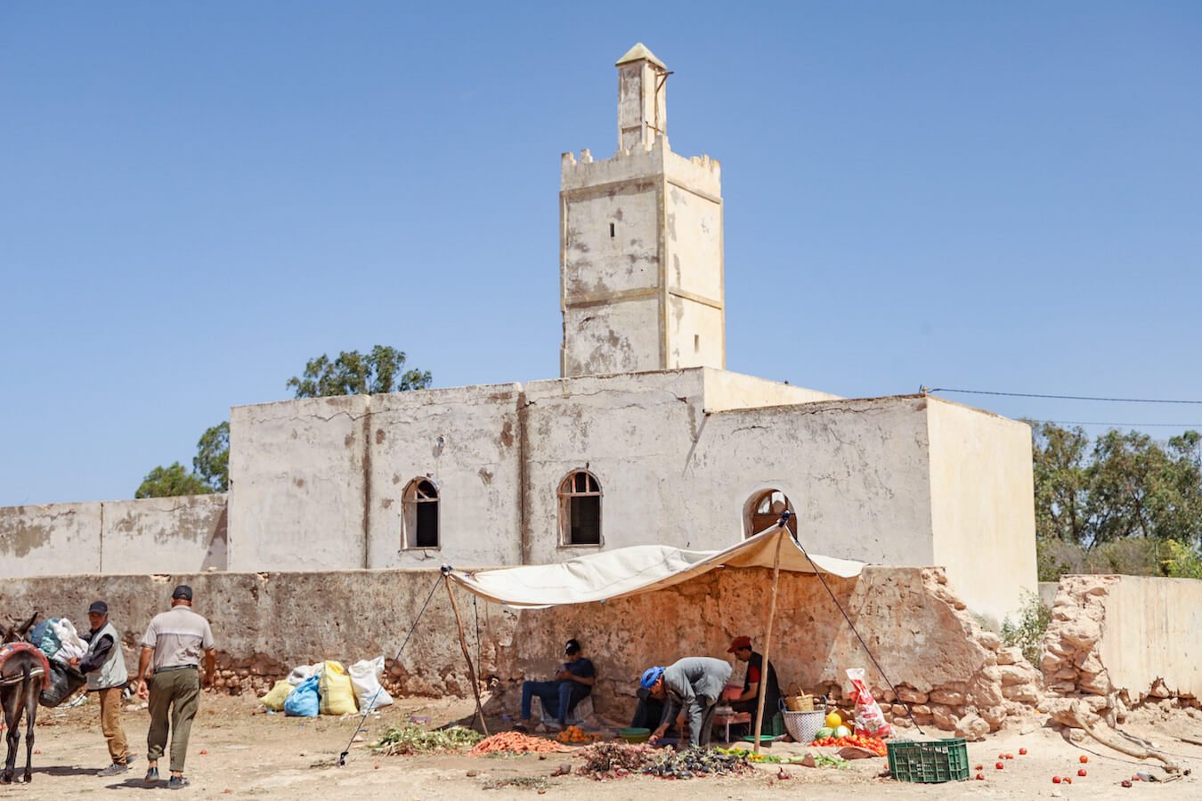 Moroccans sell vegetables in front of a derelict mosque in Ida Ougourd Market which opens only Wednesday and is 30 minutes from Essaouira.