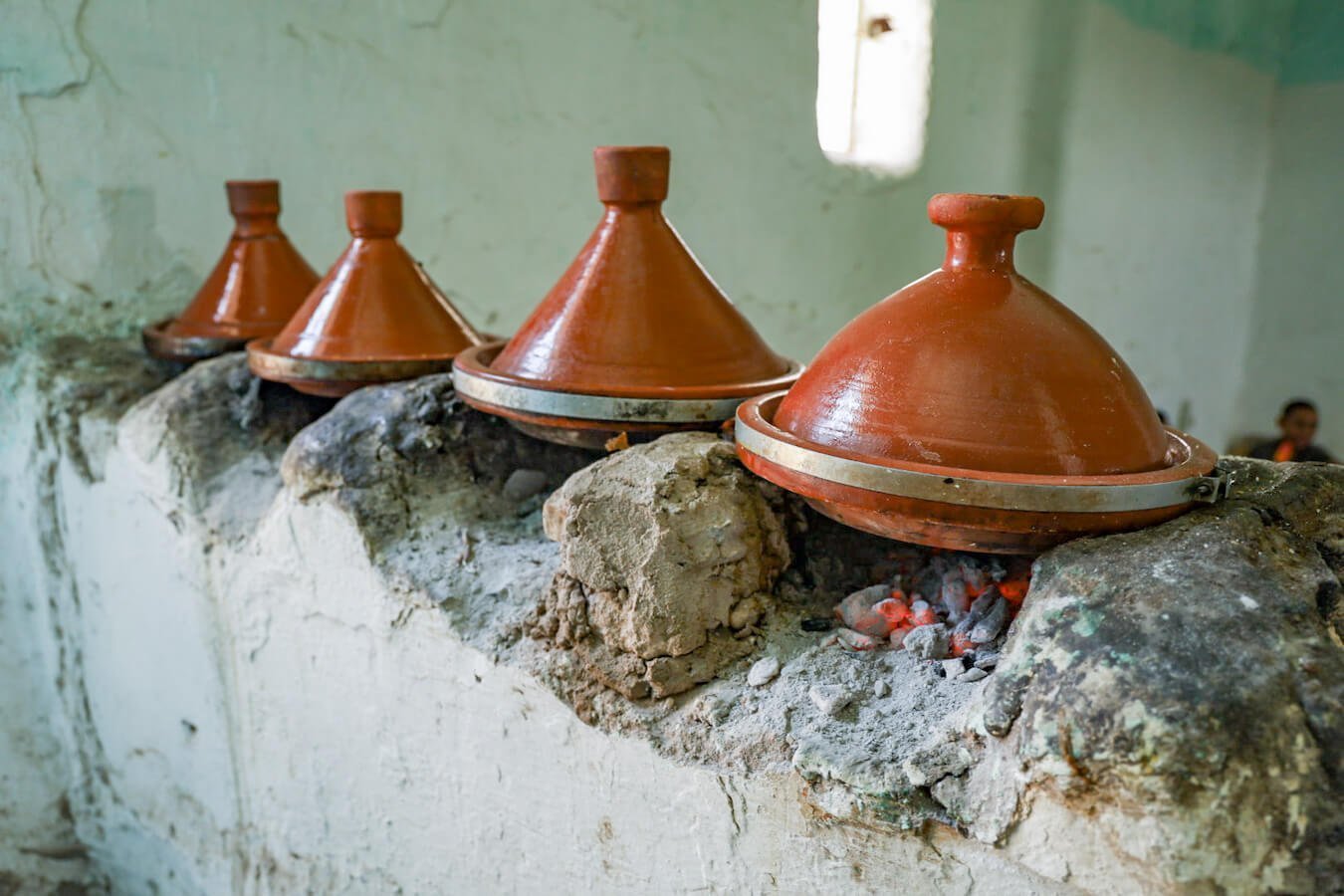 Tagines are positioned over coals at a small restaurant in Ida Ougourd Market near Essaouira