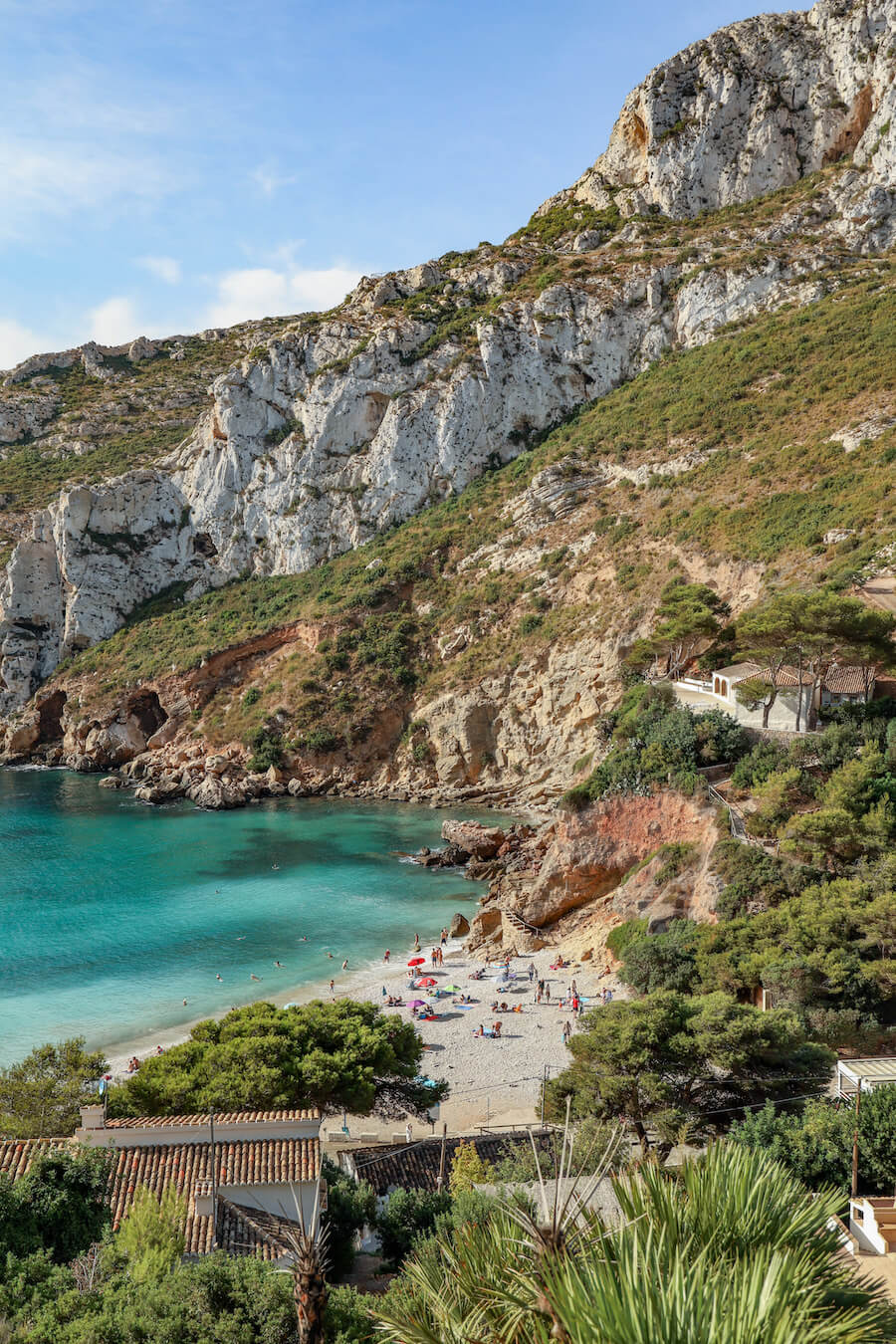 Holiday makers on vacation in Javea, sunbathe and swim at Granadella beach - a popular summer travel destination in Spain - a full guide to javea