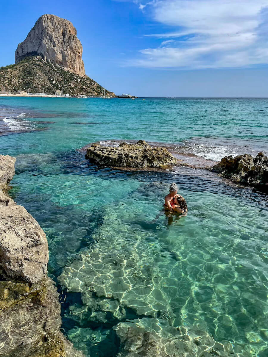 A mother and daughter swim in the beautiful Queen's Baths at Calpe on a day trip from Javea.