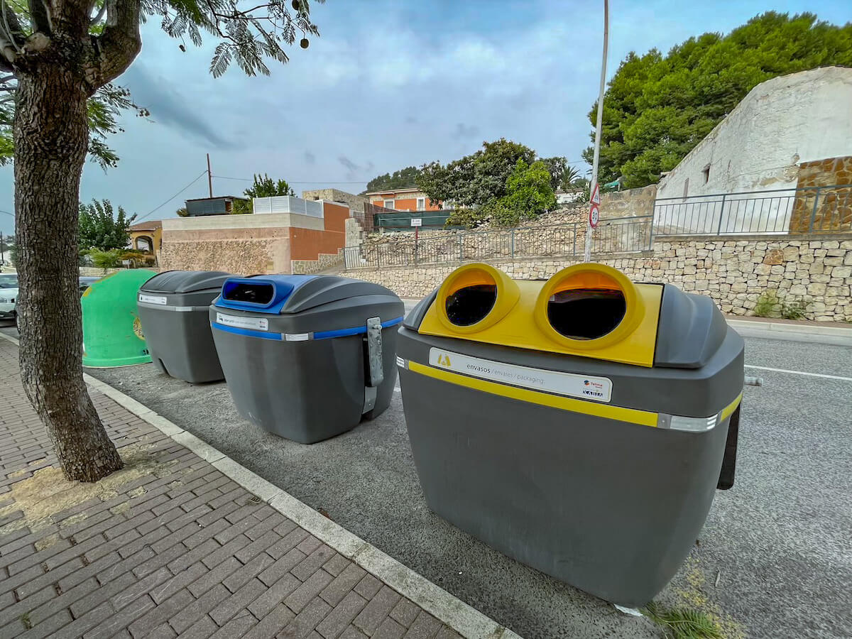 Large recycle and general household waste bins with different colours on the street in Javea - a vacation guide to Xabia