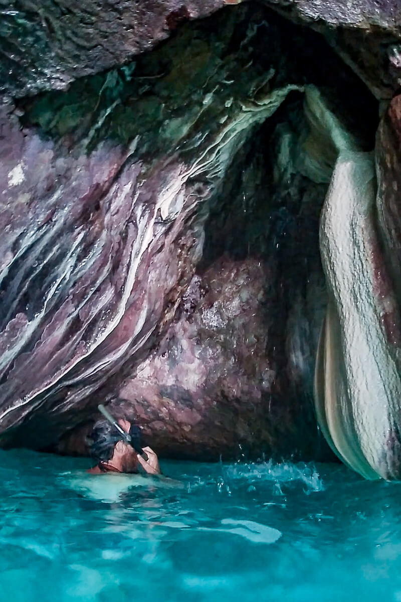 A man on vacation in Javea snorkels into a cave at one of the hidden calas - a guide to javea