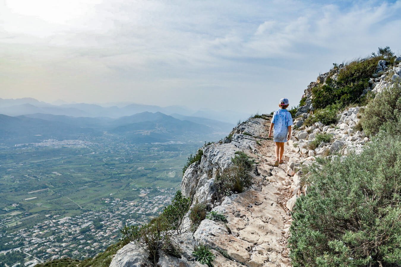 A child hikes the steep path up towards the summit of Montgo Massif.  