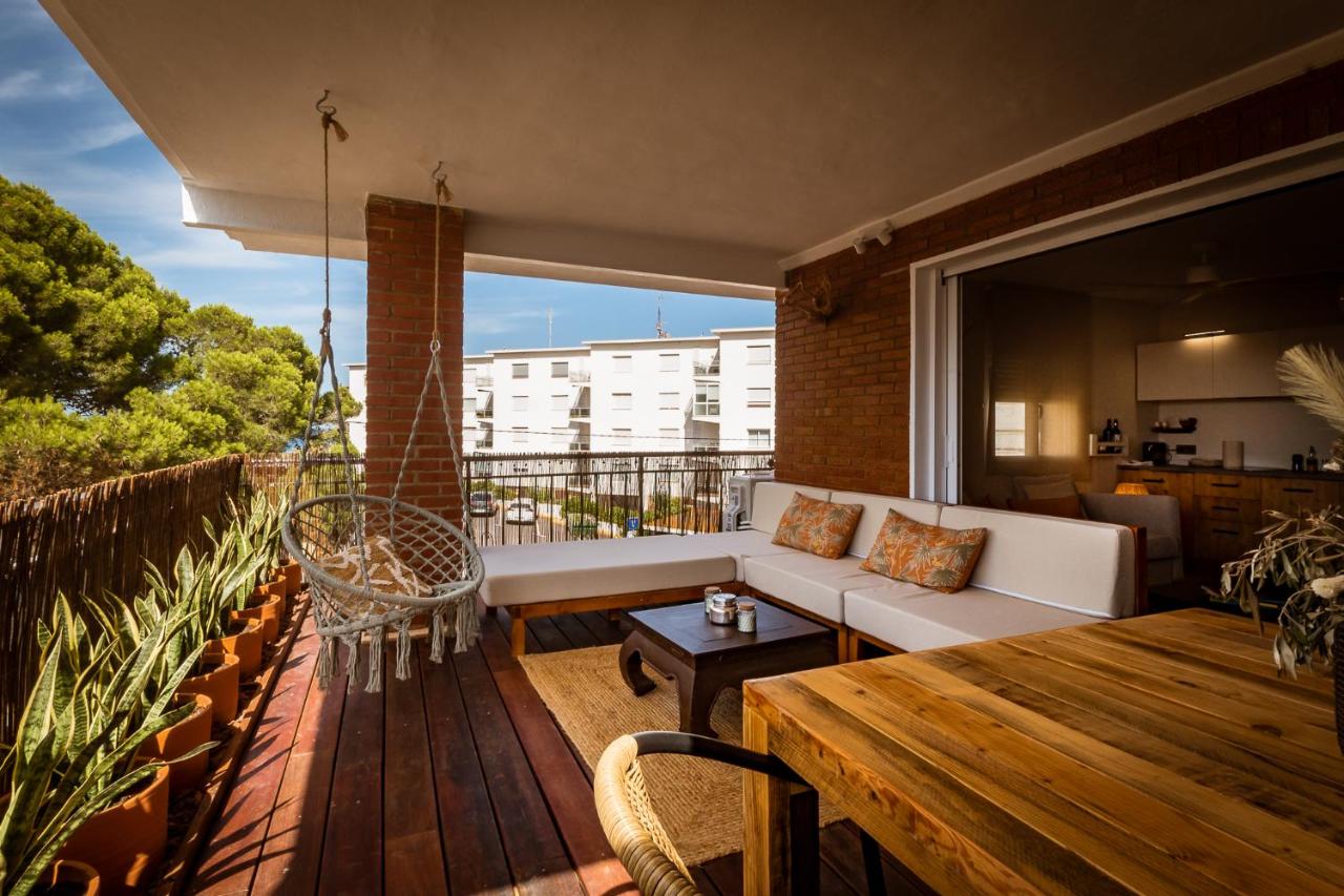 An apartment terrace with comfortable outdoor furniture and swing - holiday accommodation options available to book in Javea.