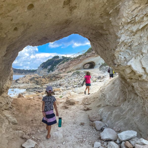 A family explore the trail of one of the well known walks in Javea / Xabia, through the caves from Cala Blanca towards Caleta del Dins.
