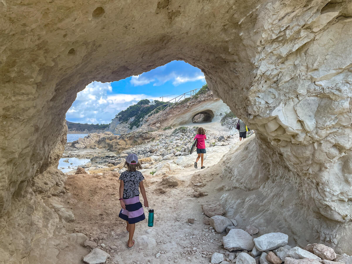 A family explore the trail of one of the well known walks in Javea / Xabia, through the caves from Cala Blanca towards Caleta del Dins.