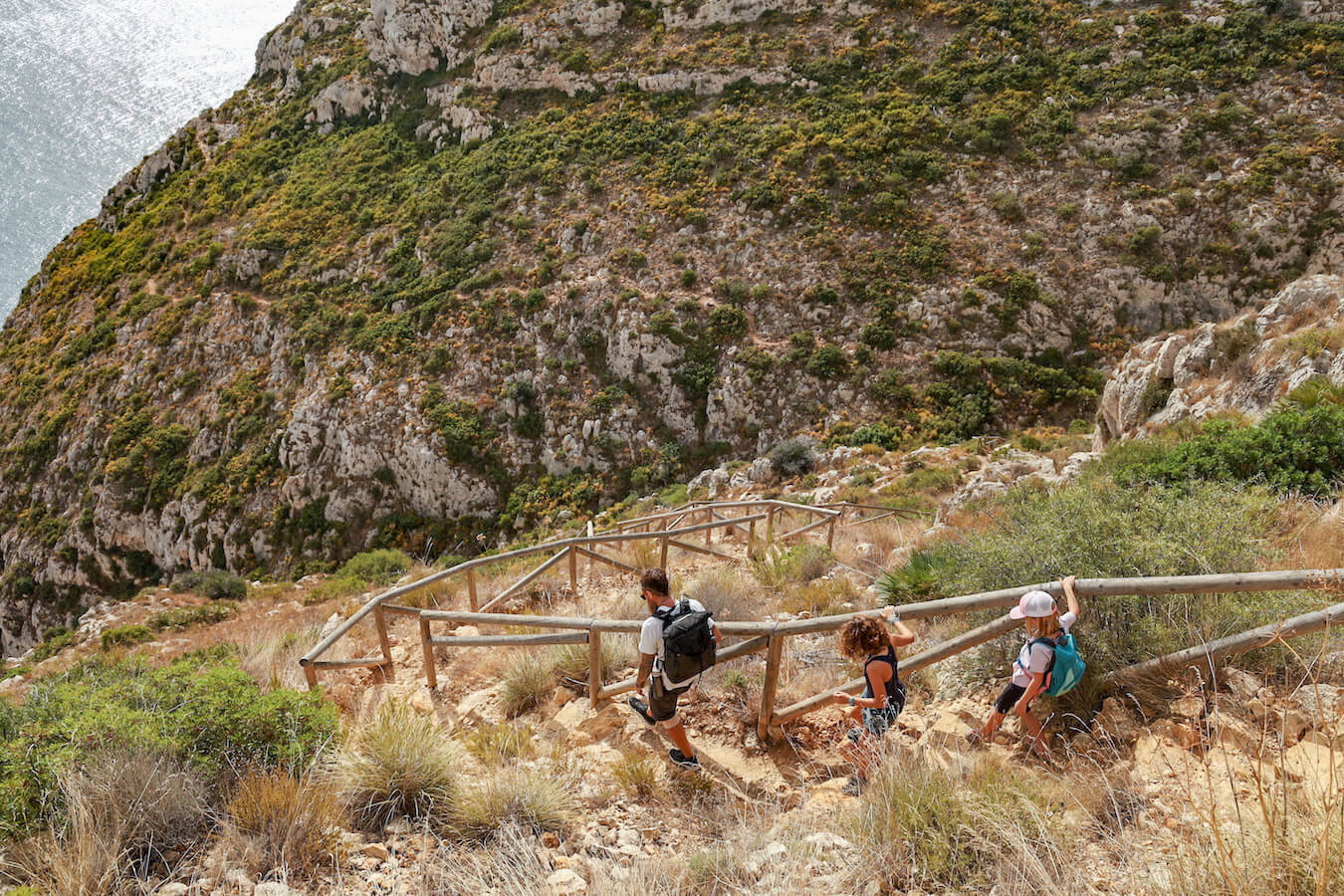 A family begin the descent into a steep ravine on the PR CV-354 hiking trail, one of the best walks in Javea.