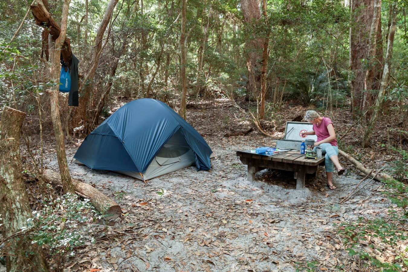 A woman cooks camp food beside her tent in the wilderness at the walkers camp at Lake Garawongera.