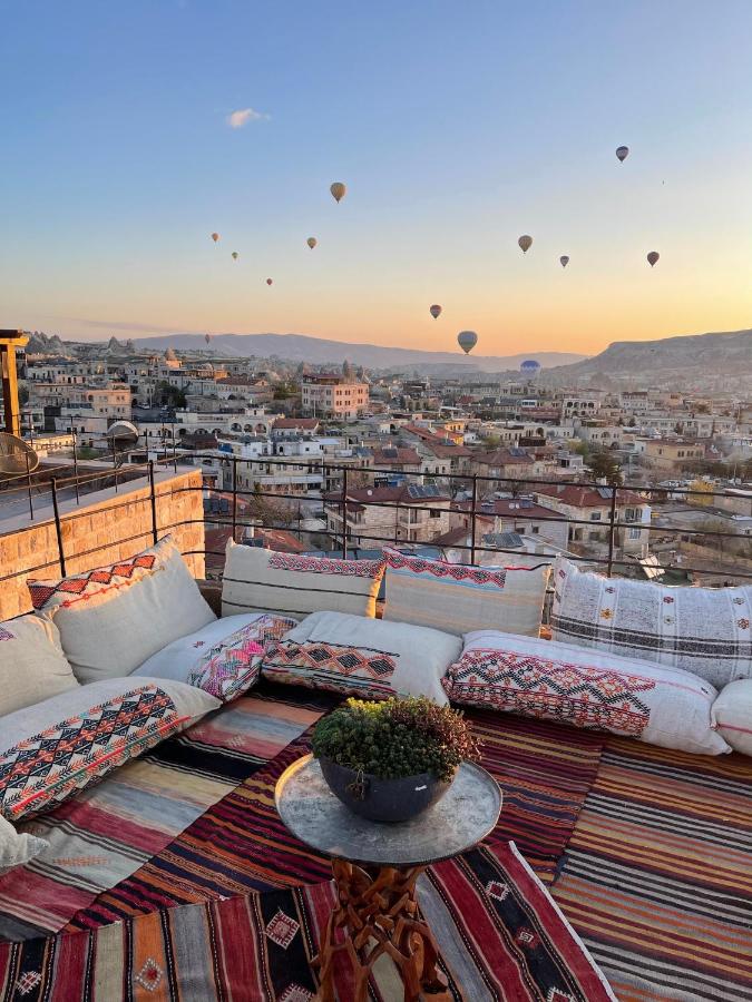 The elevated rooftop terrace of Levi Cave Hotel in Cappadocia with hot air balloons flying in the distance