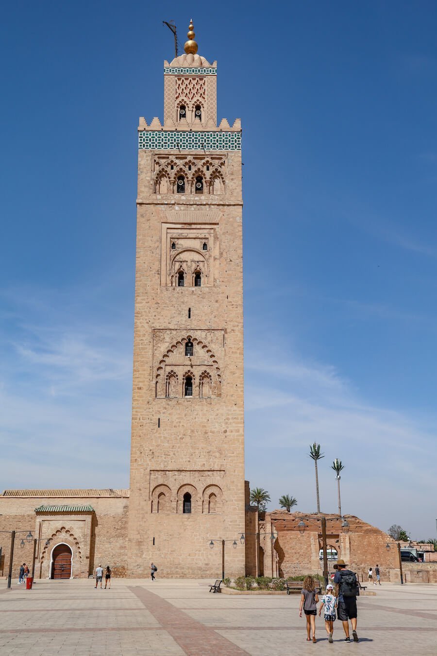 A family walk towards the iconic Koutoubia Mosque in Marrakech, a must see on a travel itinerary of Morocco.