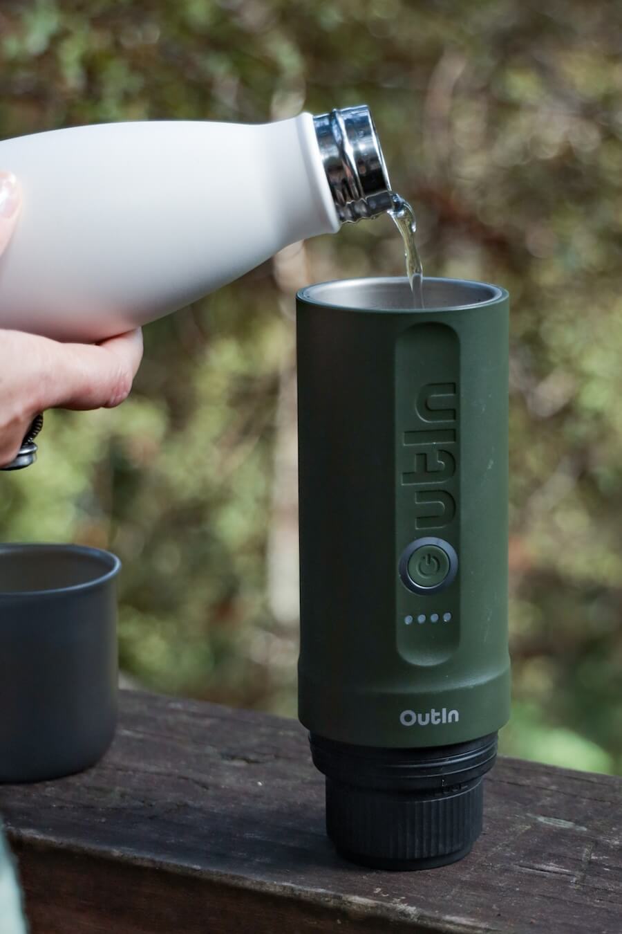 Cold water is tipped into the portable OutIn espresso machine, ready to heat the water.