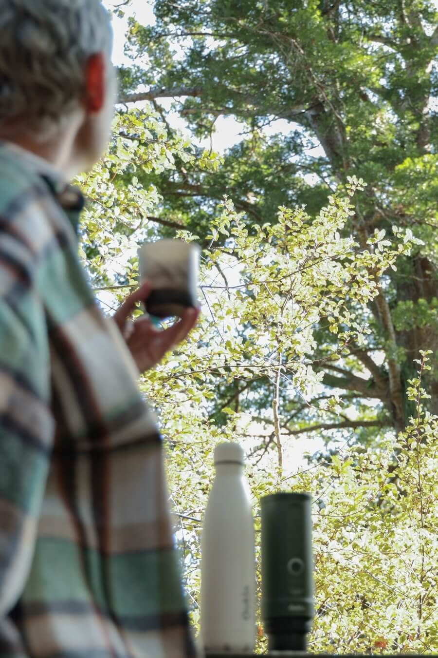 A woman drinks an OutIn espresso in nature.