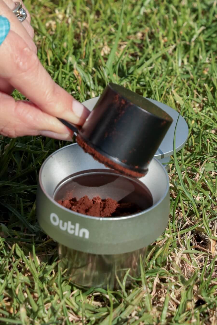 Coffee grinds are tipped into the OutIn filter basket and doser.