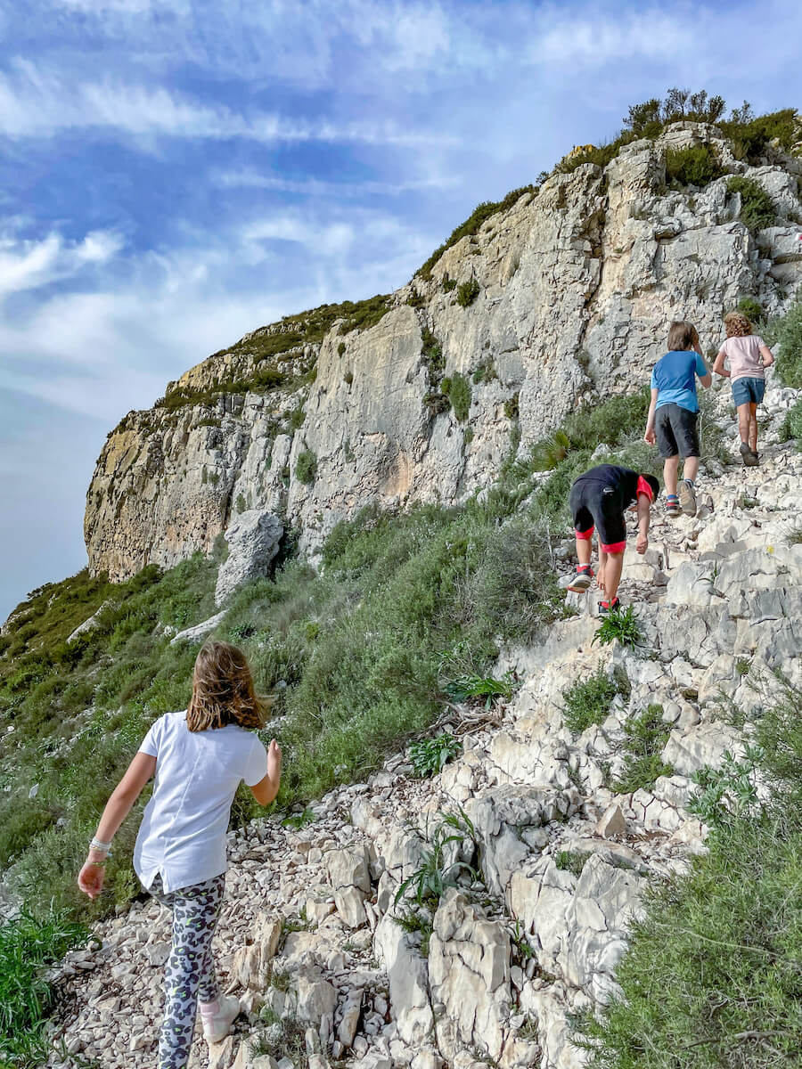 Kids hike the challenging trail near the summit in the Parque Natural in Javea, Spain.