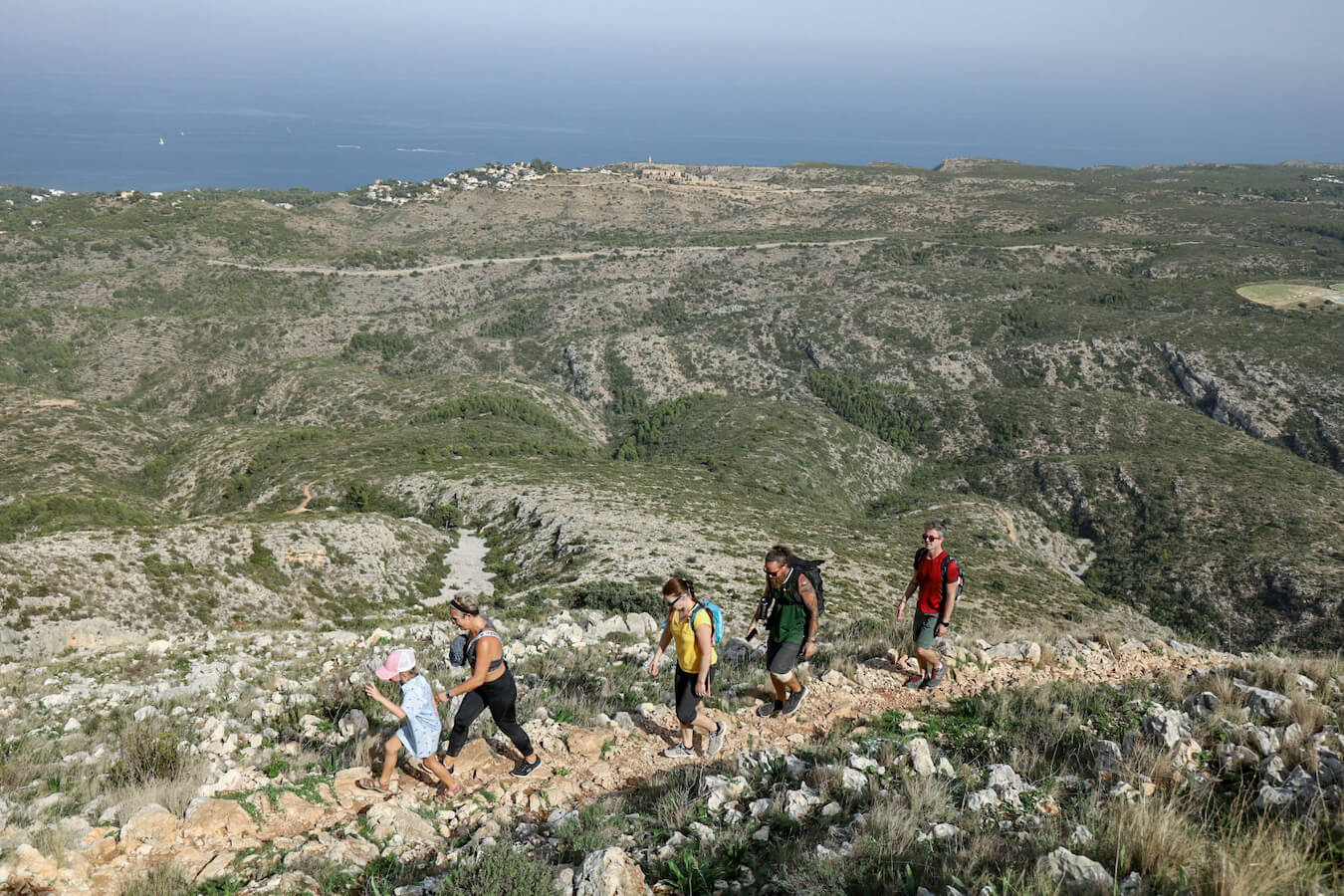 A group of hikers trekking the rocky trail of Montgo in Javea.