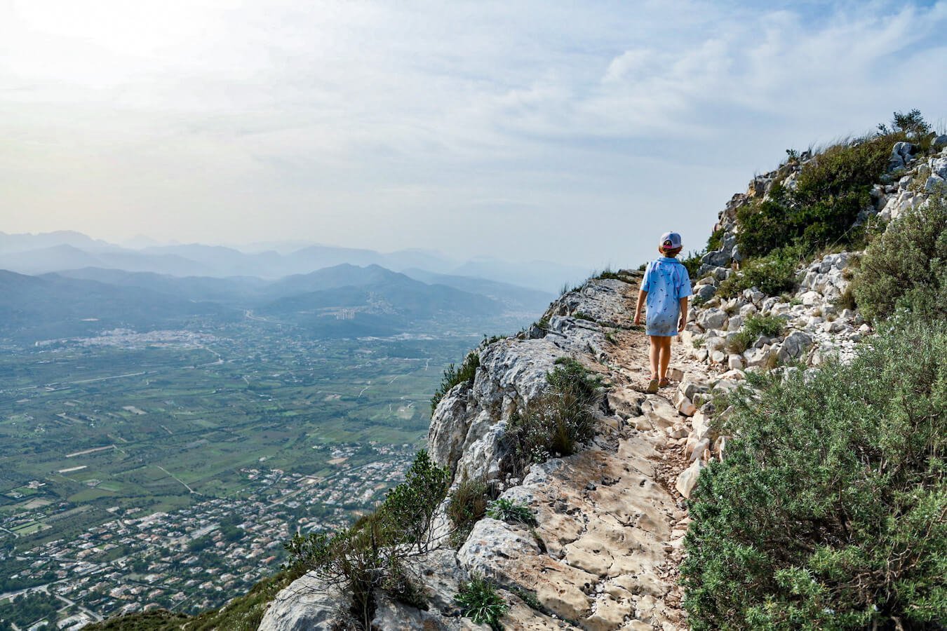 A young child hikes the challenging trail near the summit of Montgo Massif in the Parque Natural in Javea, Spain.