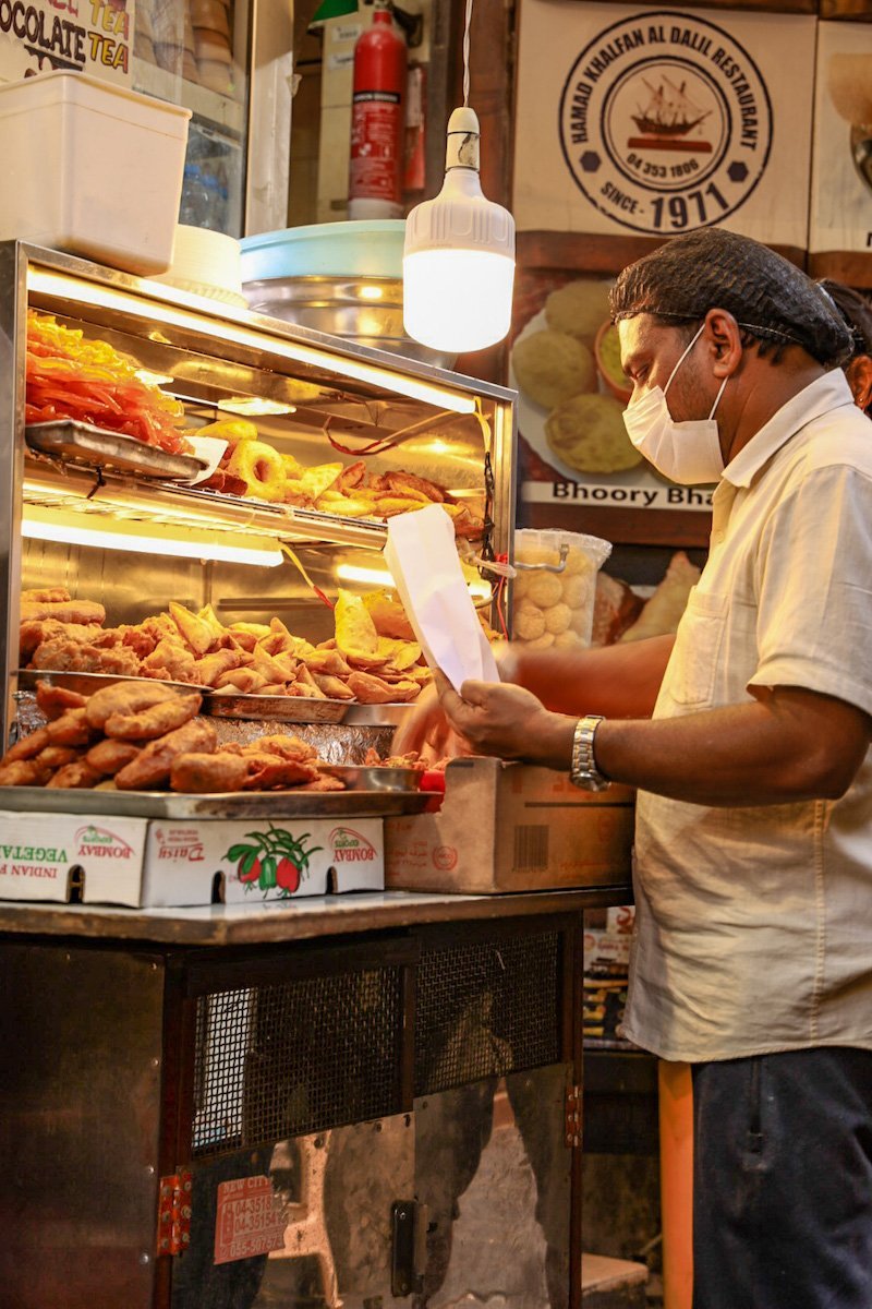 Man serves street food in the Bur Dubai Souk at the creek