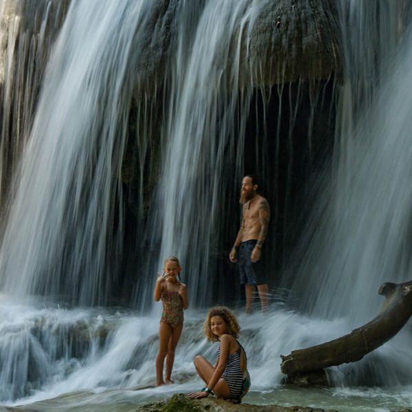 A father and his two daughters exploring the large waterfalls at Roberto Barrios Cascadas near Palenque, Mexico