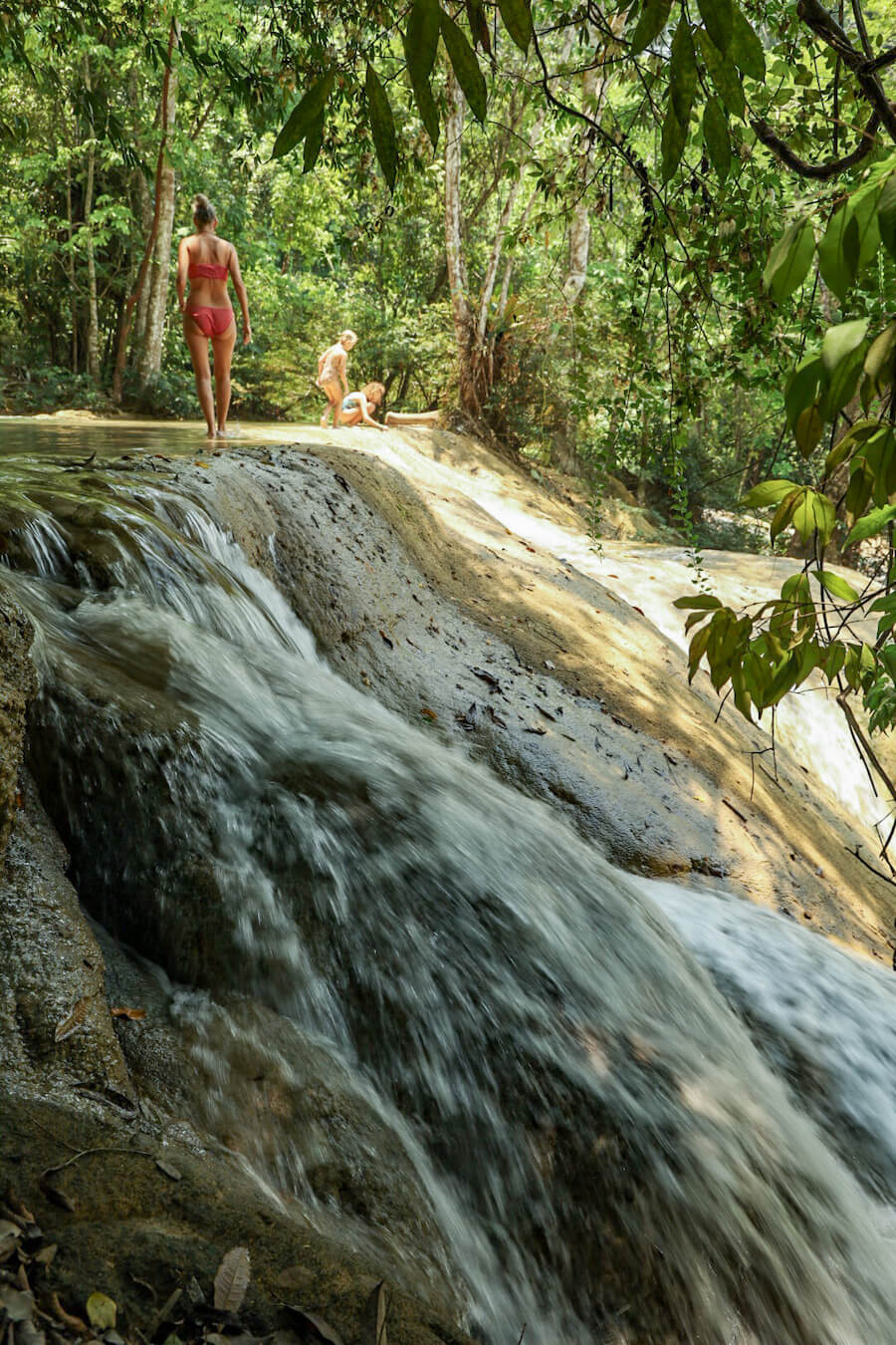 A mother and her two daughters walking along the top edge of a cascade at Roberto Barrios