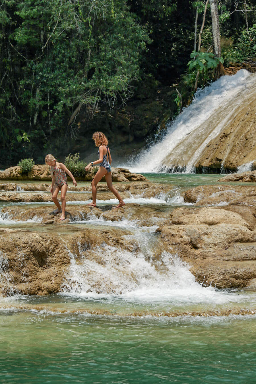Two young girls exploring a small set of cascades at Roberto Barrios in Palenque.