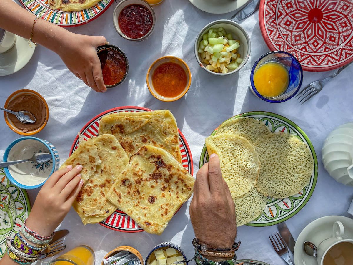 A traditional breakfast of m'semen and beghrir served with fresh juice and fruit at Ryad Watier in Essaouira.