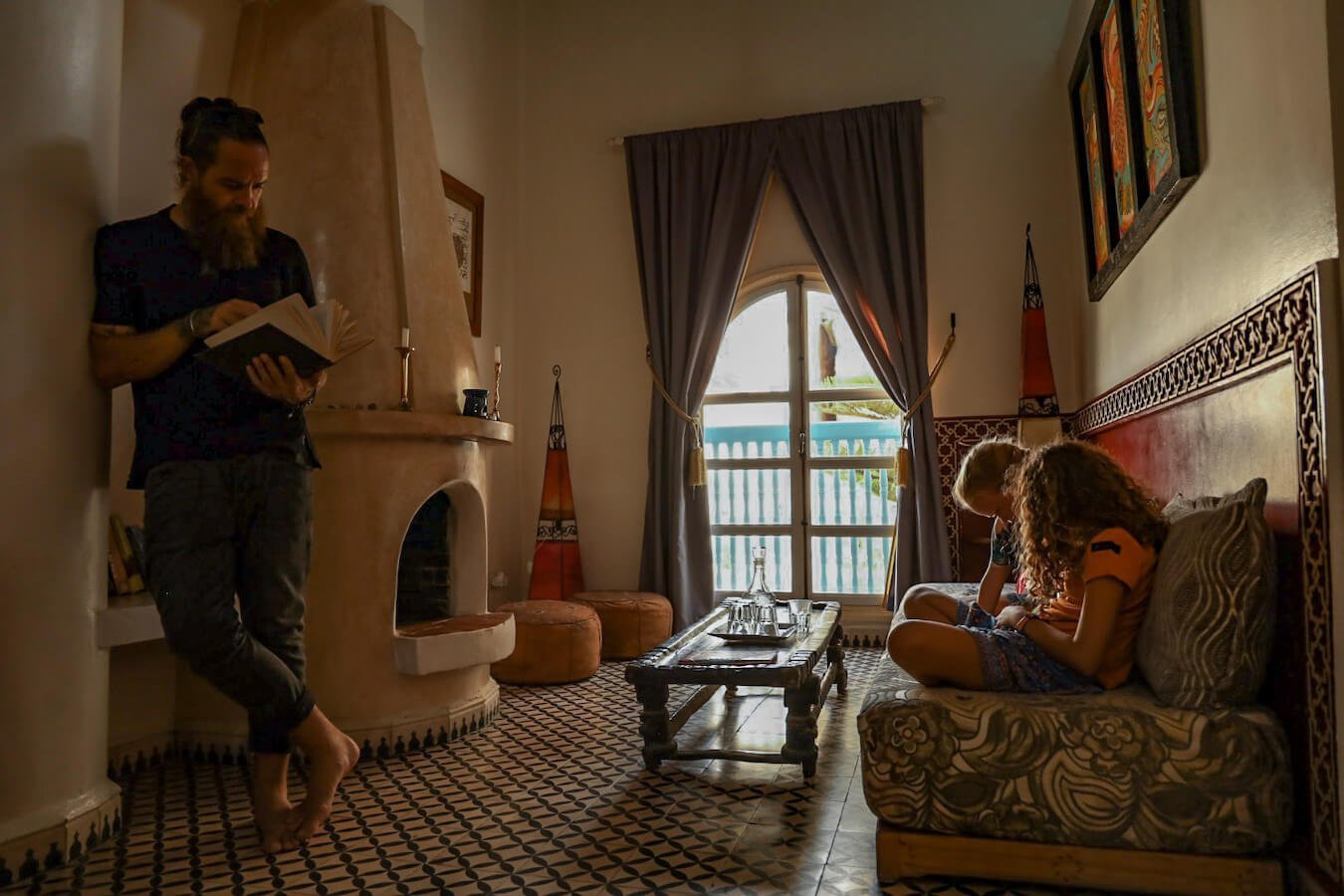 A family read books in the family suite of the Ryad Watier in Essaouira.  