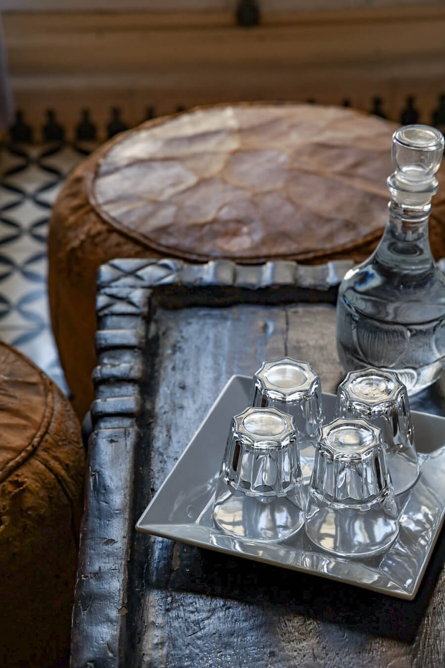 A glass jar of filtered water is served with glasses in each room at Ryad Watier - sustainable travel options.