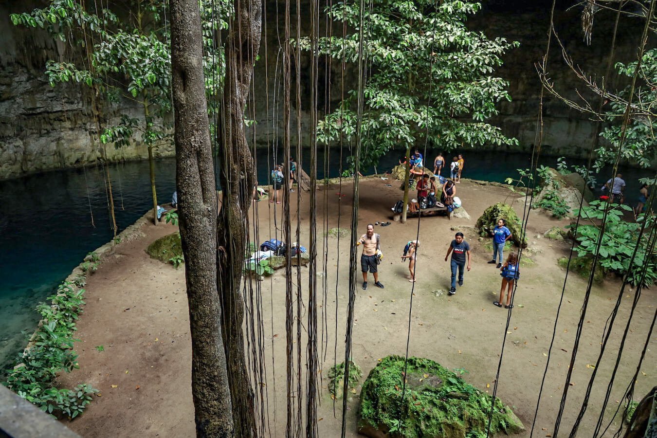 The island inside cenote Sac Aua with tourists.