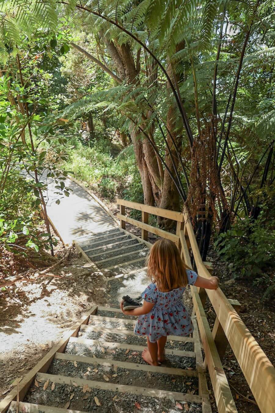A child walks down the steep stairs into Cathedral Cove.