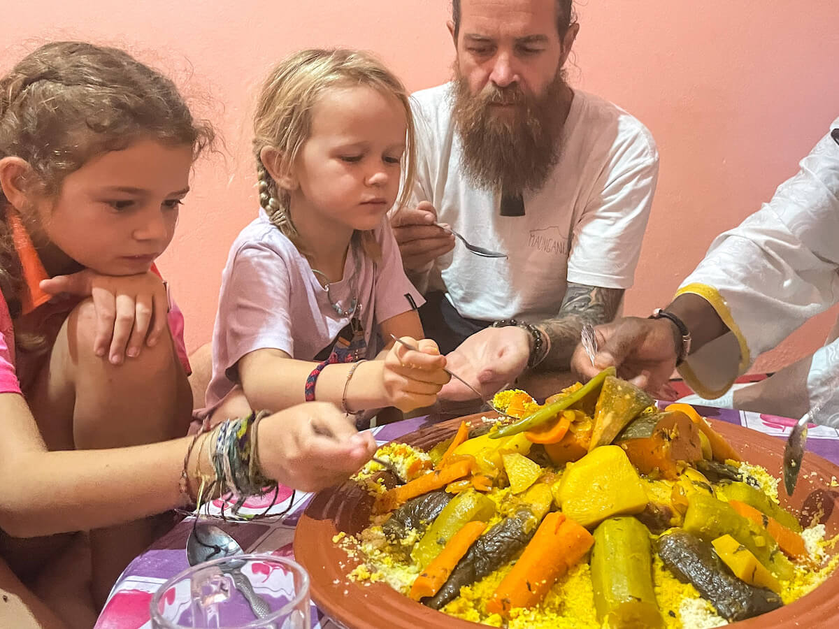 A family eat from a large plate of cous cous in Morocco