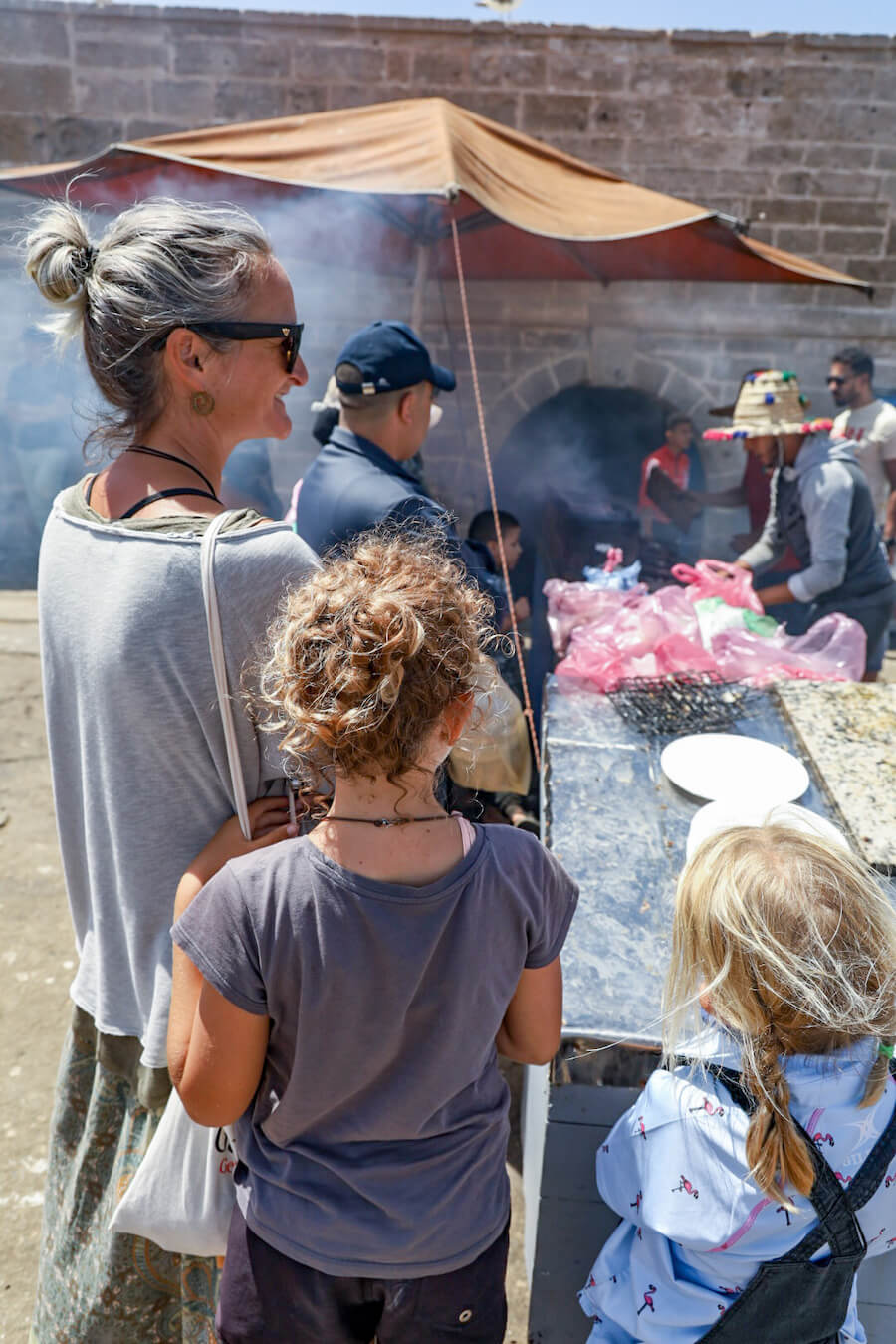 A family wait for the seafood cooking at the fishing port in Essaouira