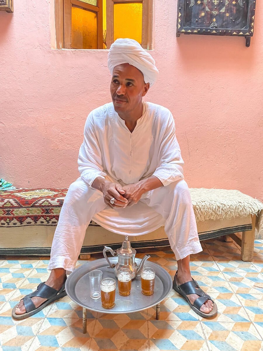 A man serves mint tea to guests in Morocco