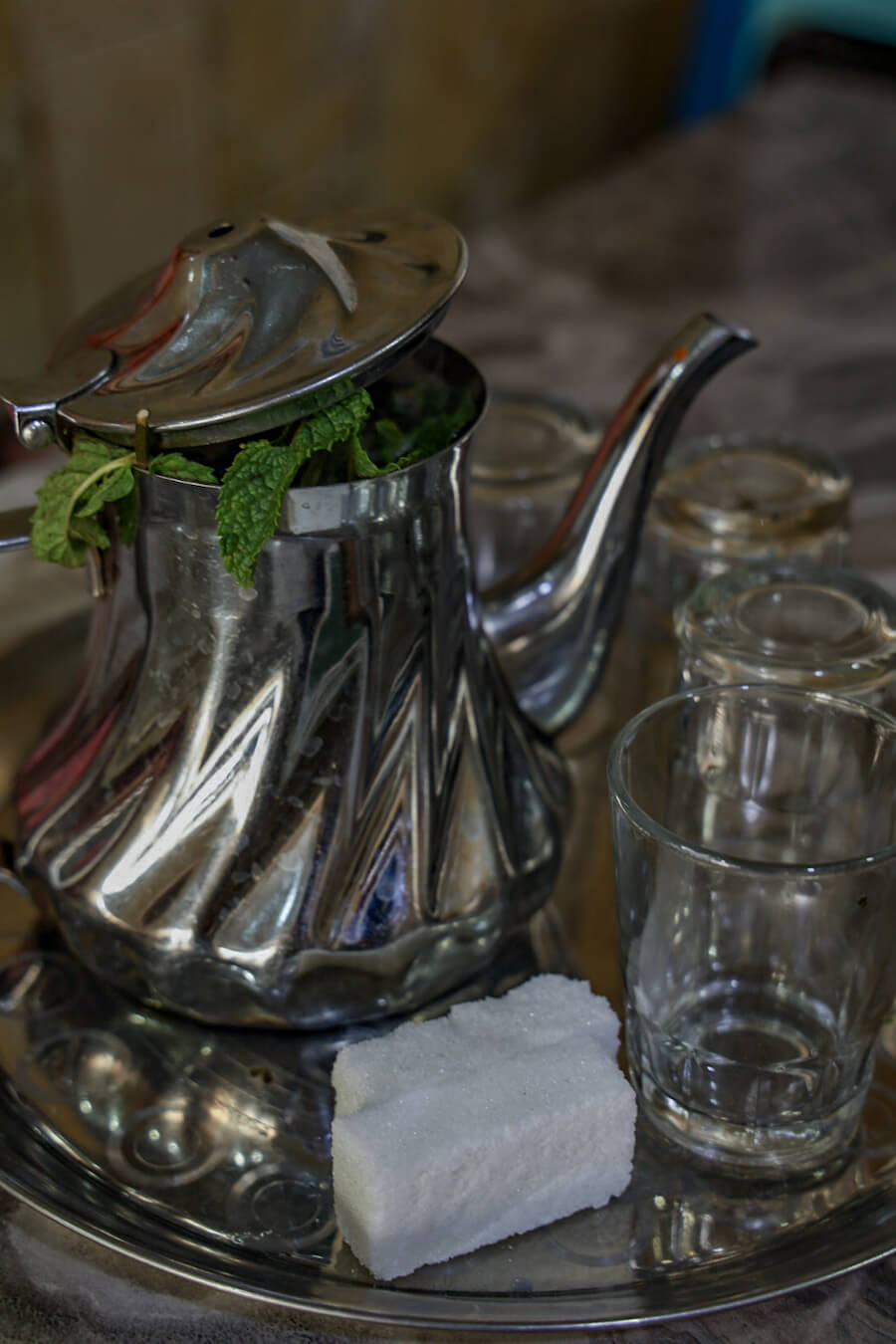 A pot of mint tea with large sugar cubes and small glasses in Morocco