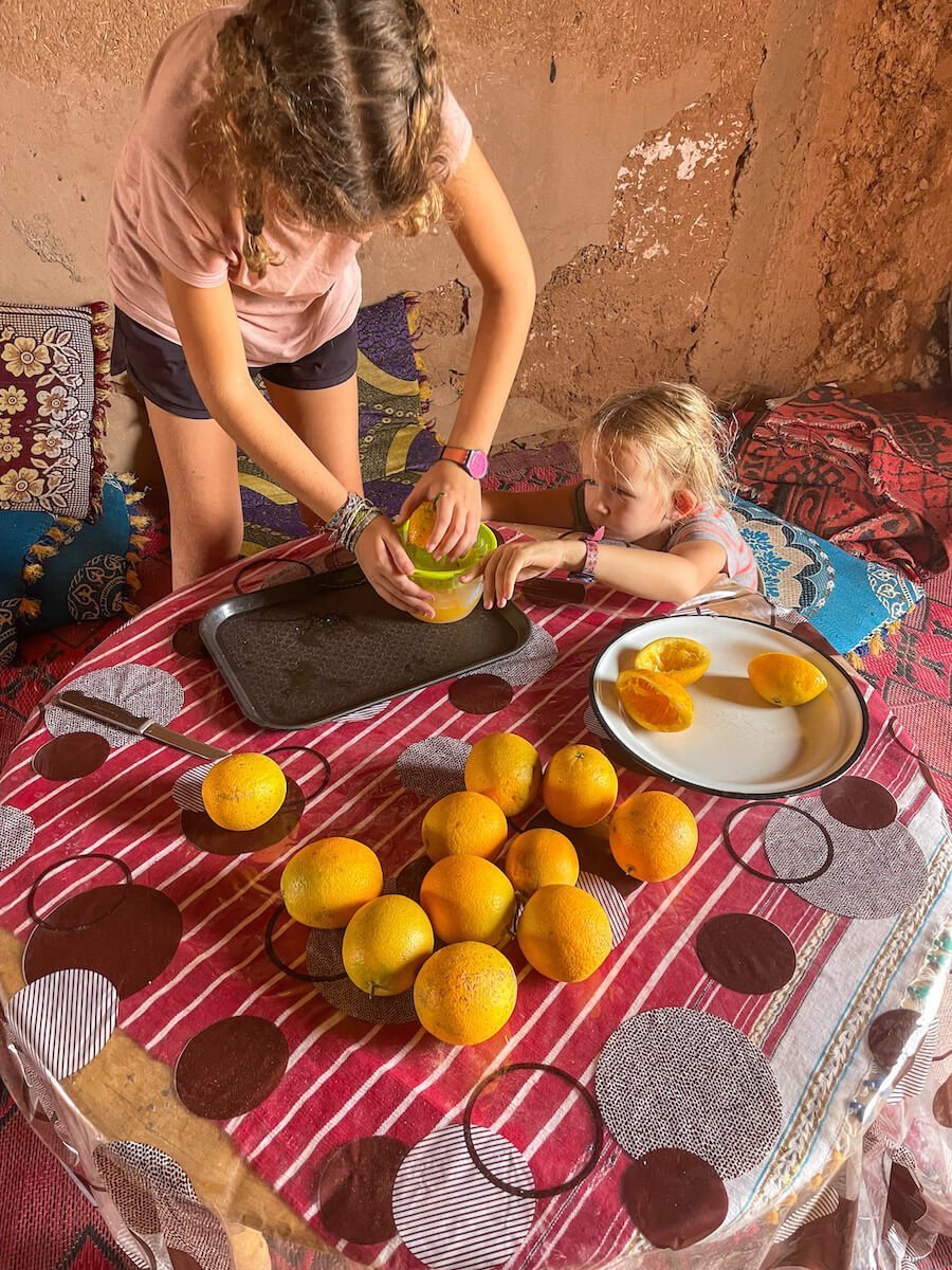 Two children squeeze fresh orange juice in Morocco