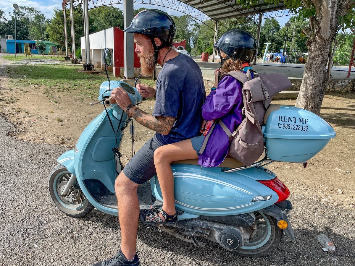Father and child take a scooter ride through cenote countryside near Valladolid in Mexico